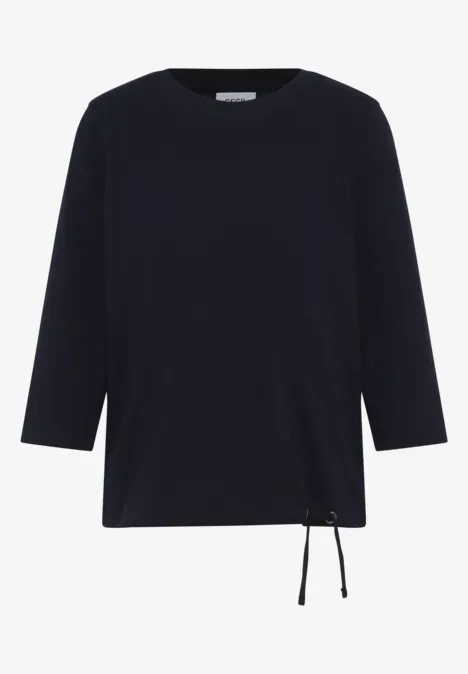 Schwarzes Langarmshirt mit Kordelzug unten rechts.